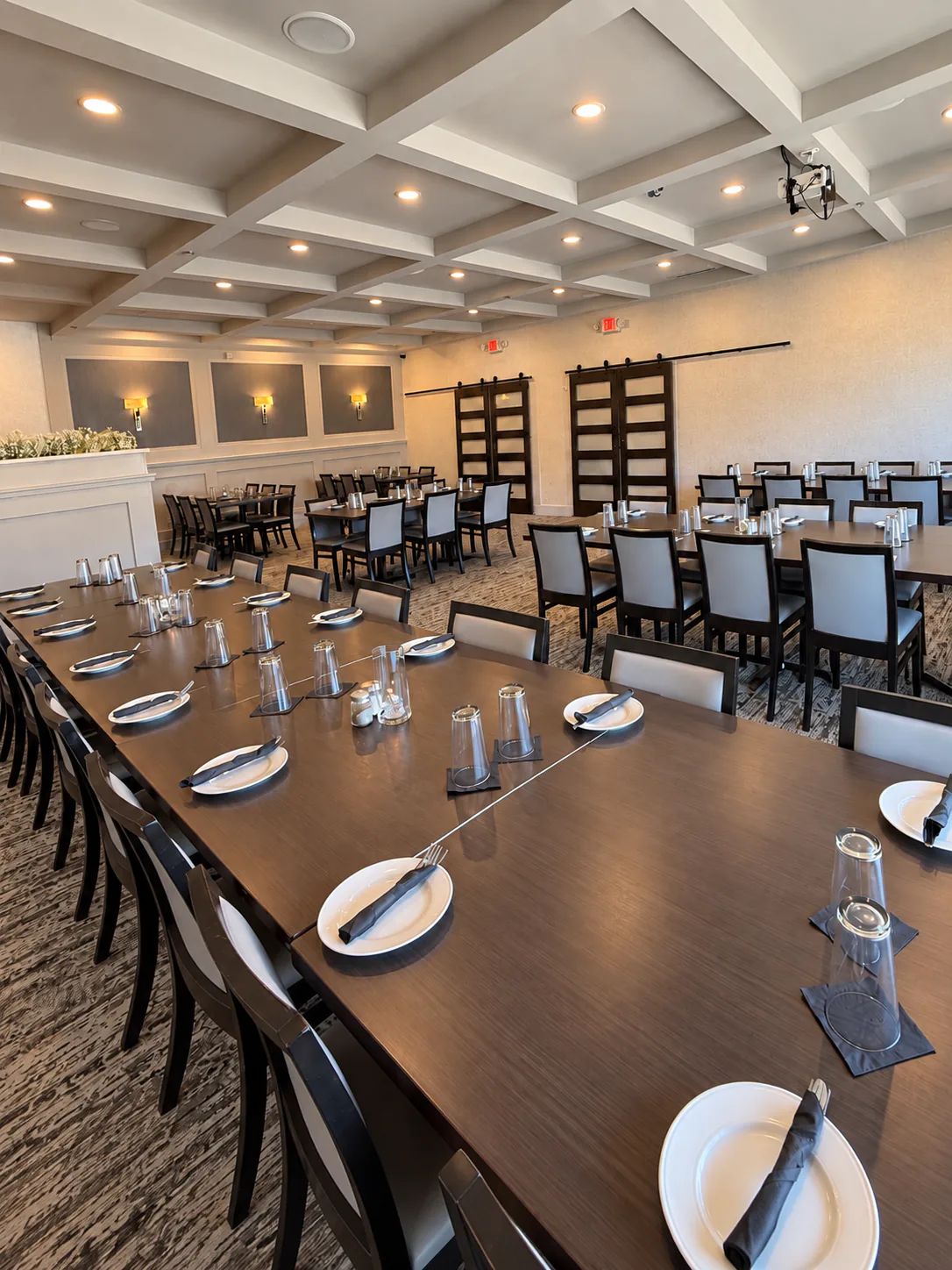 Banquet room configured with tables for a large group dinner